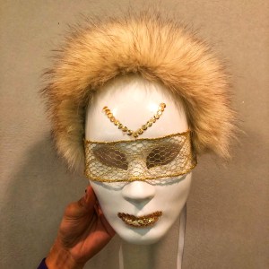 White mask with fox fur trim, gold lace blindfold, and gold lips.