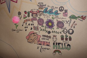 Series of drawings on brown paper. Includes a horse, waves, rainbow, word HELLO, purple flower and succulents.
