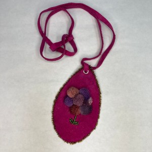 Caribou tufted flower pendant with beaded edge.